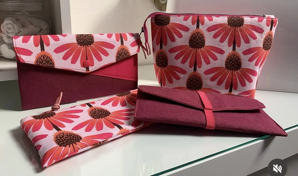 Pochette in tessuto con grandi fiori rosa e dettagli color lampone